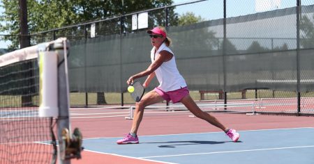 Woman dressed in fashionable pickleball apparel while playing on an outdoor court