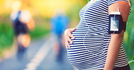 Can You Play Pickleball When Pregnant? Pregnant woman exercising outside with her hand on her belly