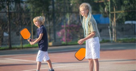 How to Teach Pickleball to Beginners A young boy and girl learning pickleball