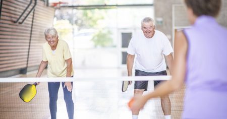 Older pickleball players play on indoor pickleball court