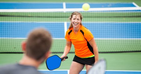7 Characteristics of the Best Pickleball Coaches Woman playing pickleball with a pickleball coach