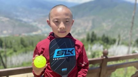Colorado Picklers Busy With Charities And Taking The Game To Bhutan! Boy holding pickleball in Bhutan - Image courtesy of Kathleen Kiefer on youtube.com