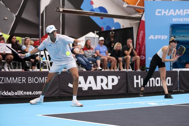 How to Serve in Pickleball: Rules, Technique and Every Type of Serve Pro pickleball player hitting an underhand serve with contact below the waist while his partner waits at the baseline